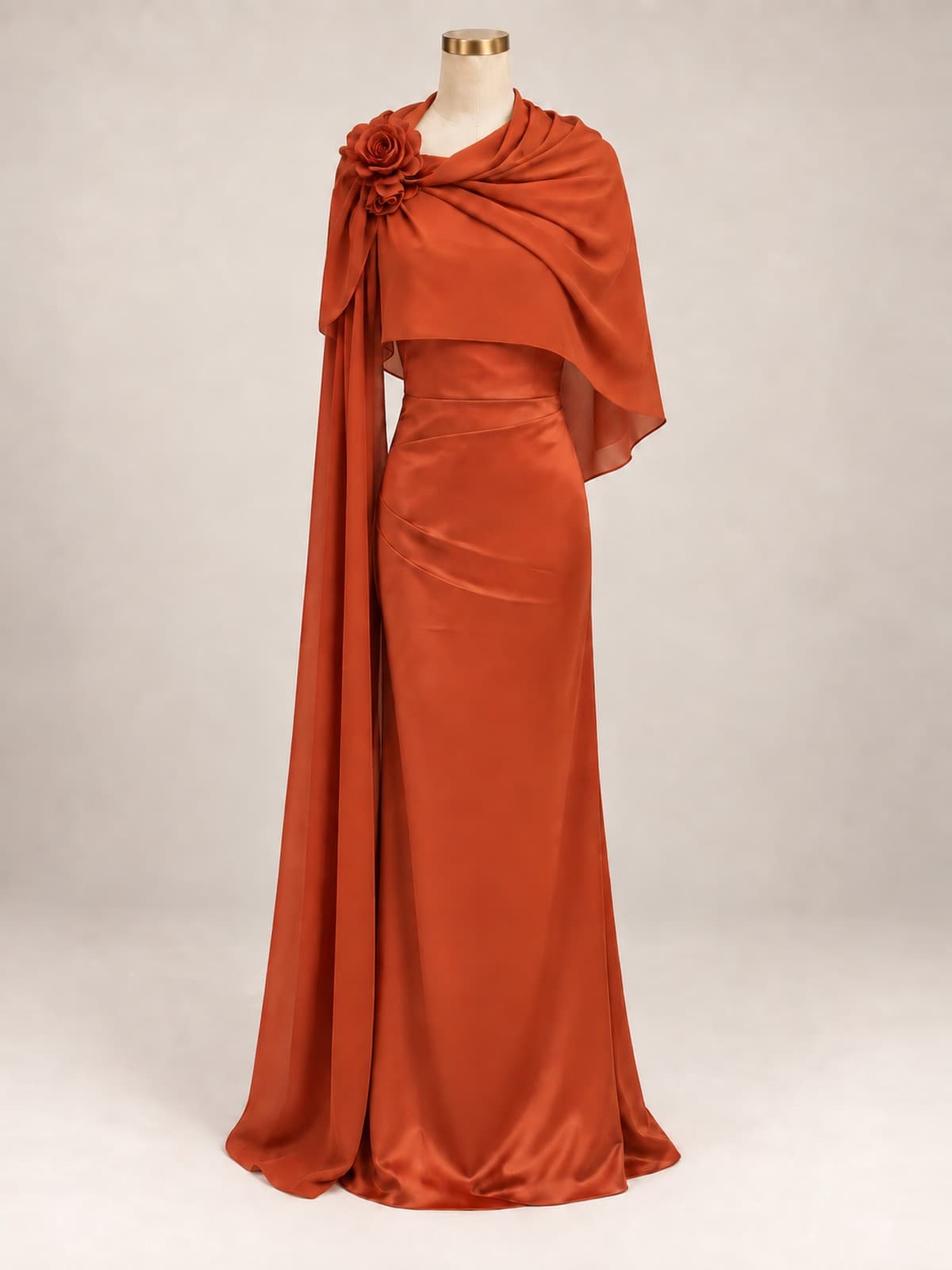Vestido de festa Estela: cetim terracota, capa drapeada sobre um ombro com rosas de tecido, silhueta coluna, em manequim de ateliê.
