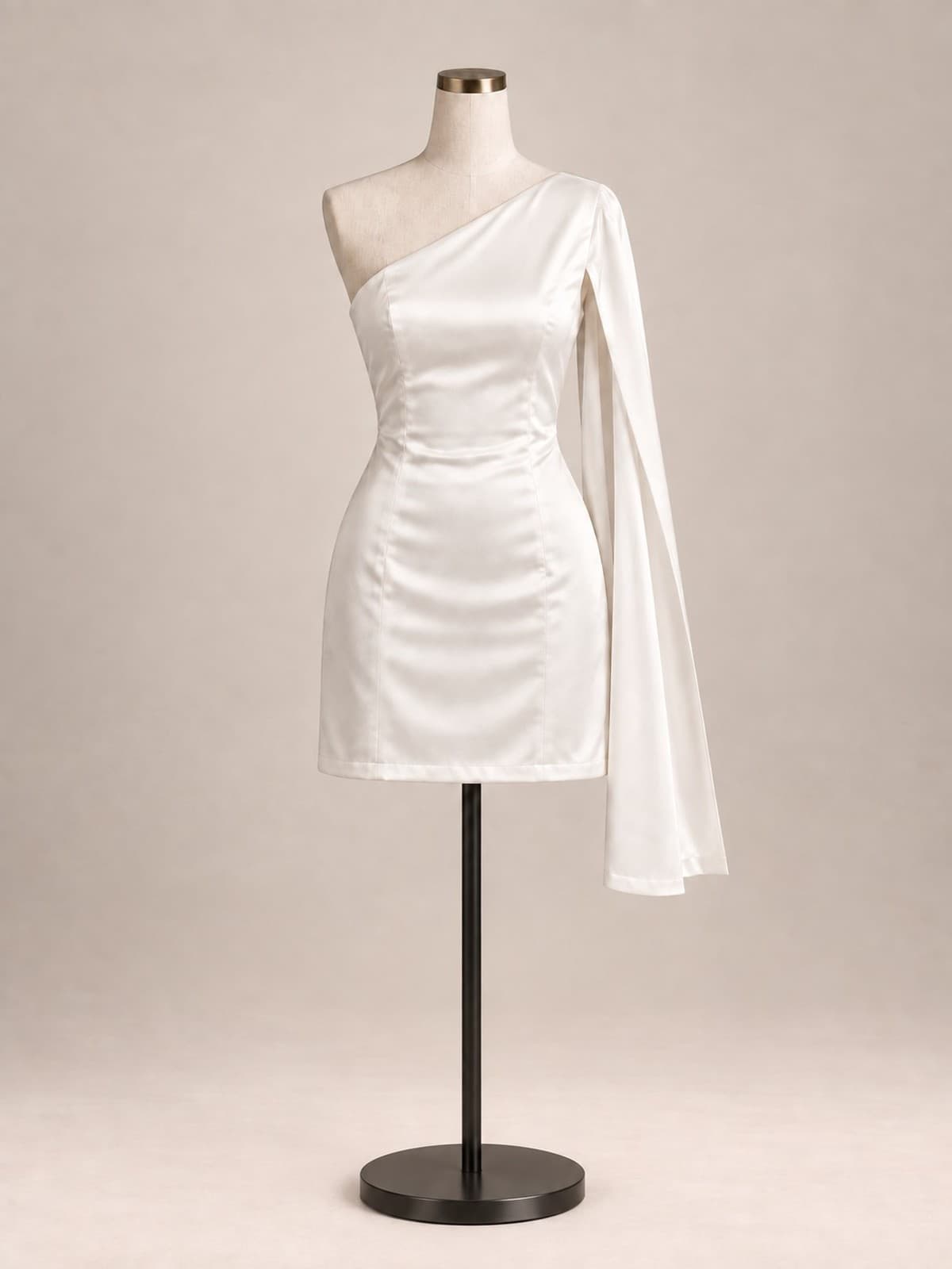 Vestido de festa Neve: cetim marfim, decote de um ombro só com manga-capa longa e fluida, corpo justo e comprimento curto, em manequim de ateliê.